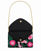 Black handbag with floral embroidery and a gold chain strap on a white background