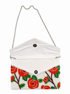 White clutch with red floral design on a white background